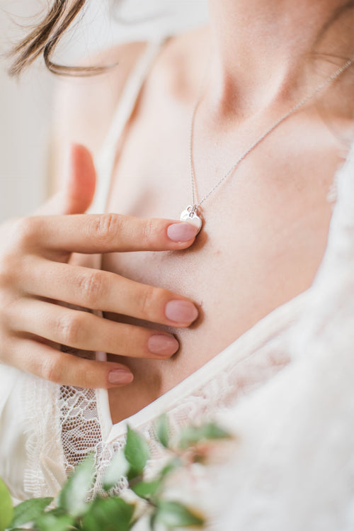 Femme portant un pendentif commémoratif délicat autour du cou